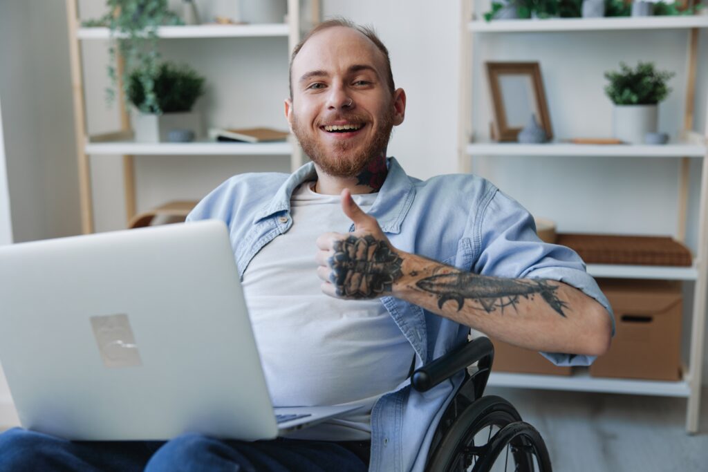 cheerful man using laptop in wheelchair indoors 2026 03 19 23 48 54 utc