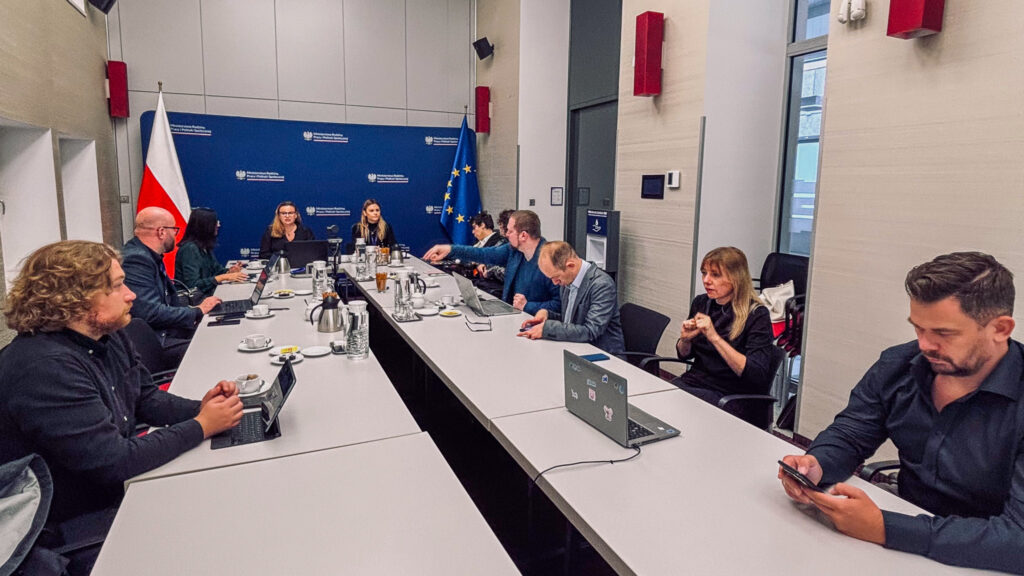 Rada Programowa Centrum Komunikacji rozpoczęła działalność 1 Uczestnicy pierwszego posiedzenia Rady Programowej Centrum Komunikacji siedzą przy stole konferencyjnym w siedzibie MRPiPS. W tle flagi Polski i Unii Europejskiej.